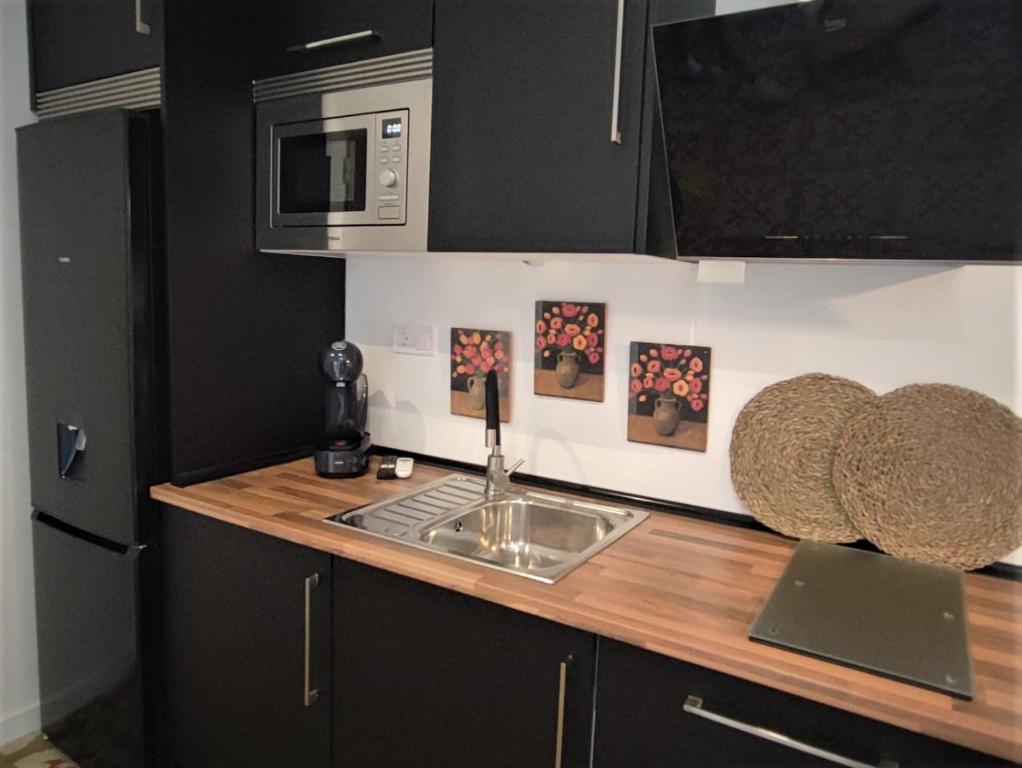 um balcão de cozinha com um lavatório e um micro-ondas em Apartamento Merlot 11 em Novelda