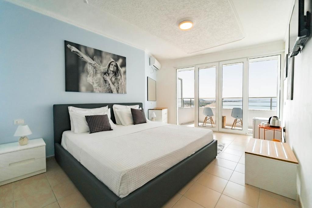 a bedroom with a bed with a view of the ocean at Beachfront Marilyn in Durrës