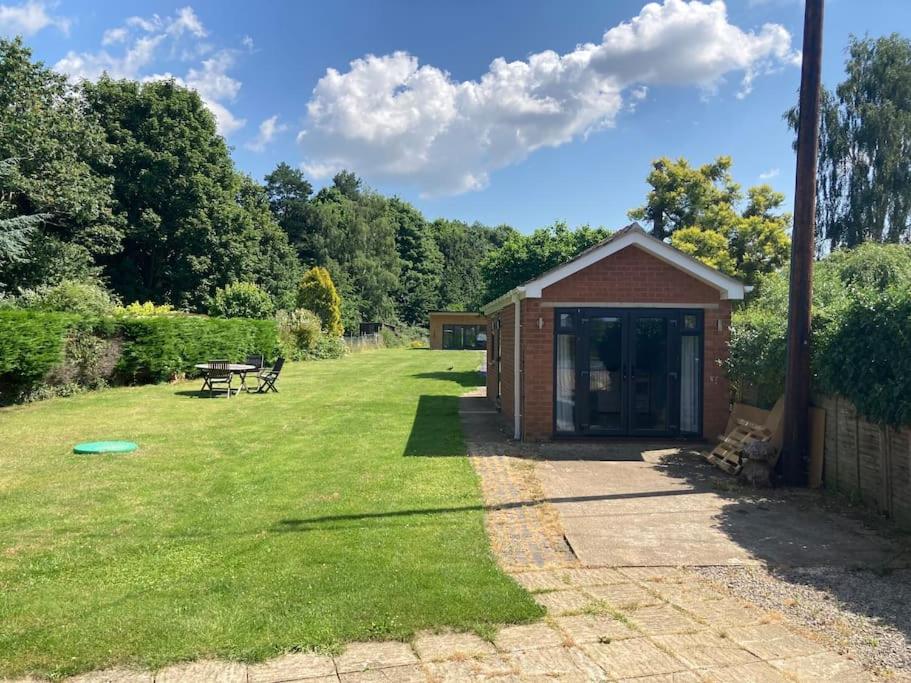 a small shed in a grassy yard with a picnic table at Garden Annexe in Kinsham