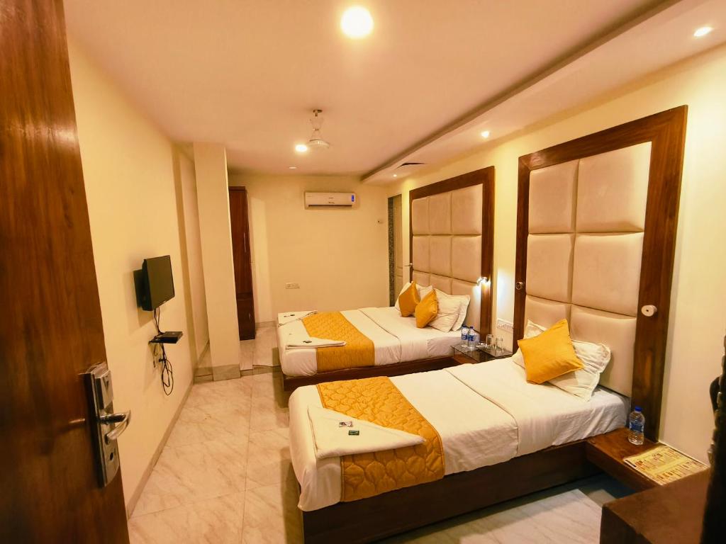 a hotel room with two beds and a television at Apex Hotel in Mumbai