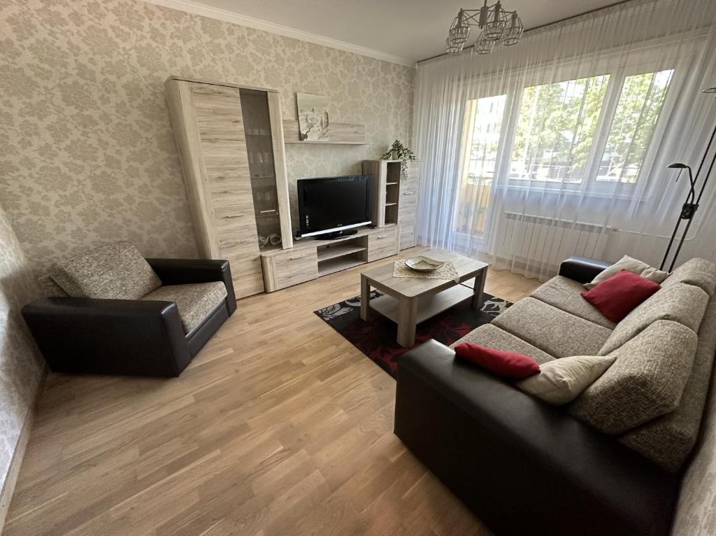 - un salon avec un canapé et une télévision dans l'établissement Pärnu Sunshine Majutus, à Pärnu