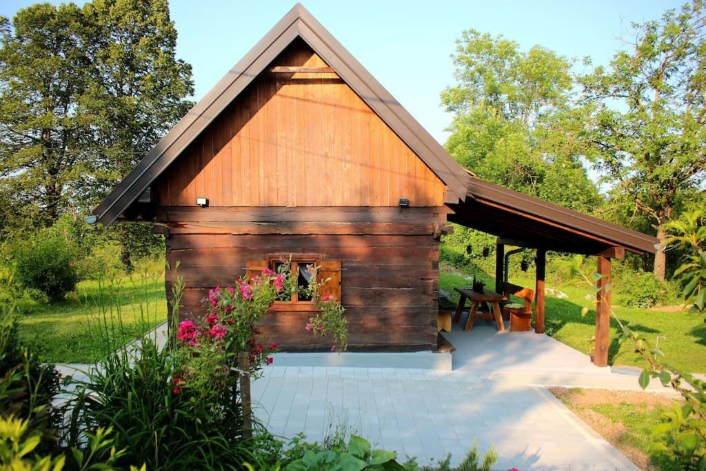 una baita di tronchi con un tavolo da picnic di fronte ad essa di Holiday home The Hive a Slunj