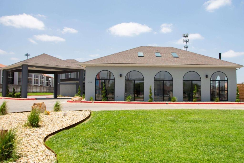 a house with a lawn in front of it at Days Inn by Wyndham Amarillo - Medical Center in Amarillo