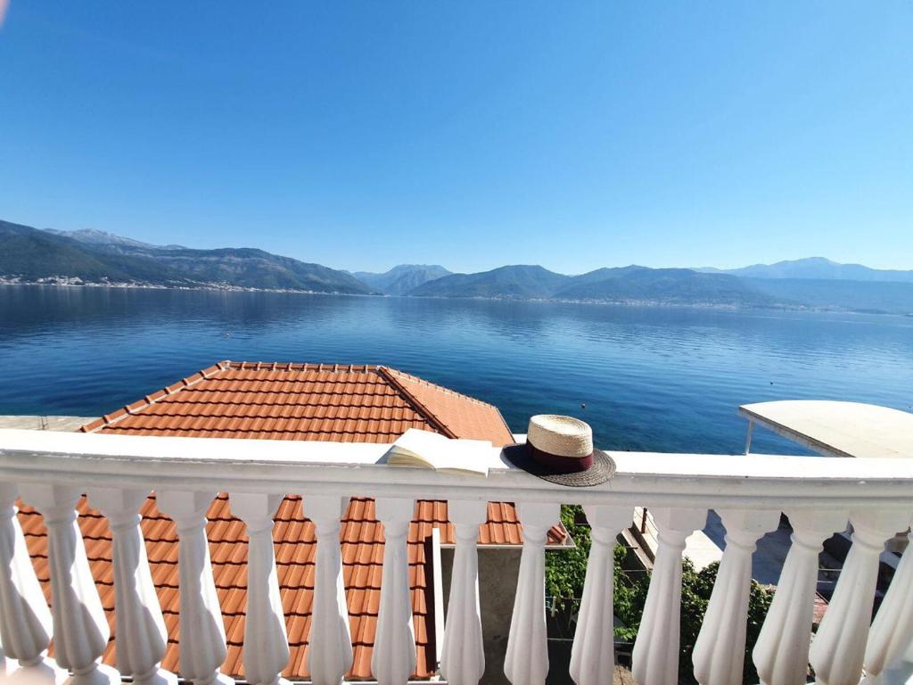 a hat sitting on a balcony overlooking the water at La casa di Sonja in Tivat