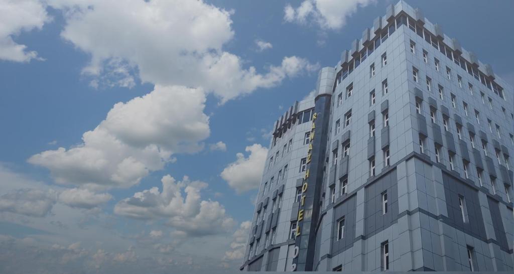 Un grand bâtiment blanc avec des nuages dans le ciel dans l'établissement Rawaz Hotel & Motel, à Sulaymaniyah