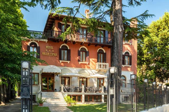a large red building with a tree in front of it at Hotel Villa Cipro in Venice-Lido