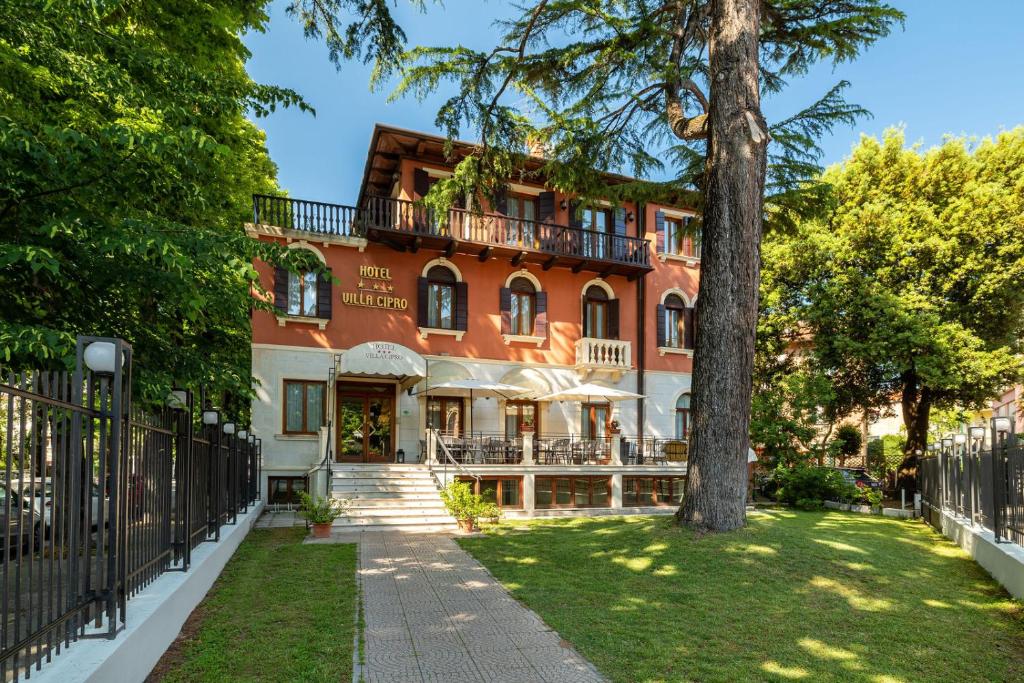 un edificio con un árbol delante de él en Hotel Villa Cipro, en Lido de Venecia