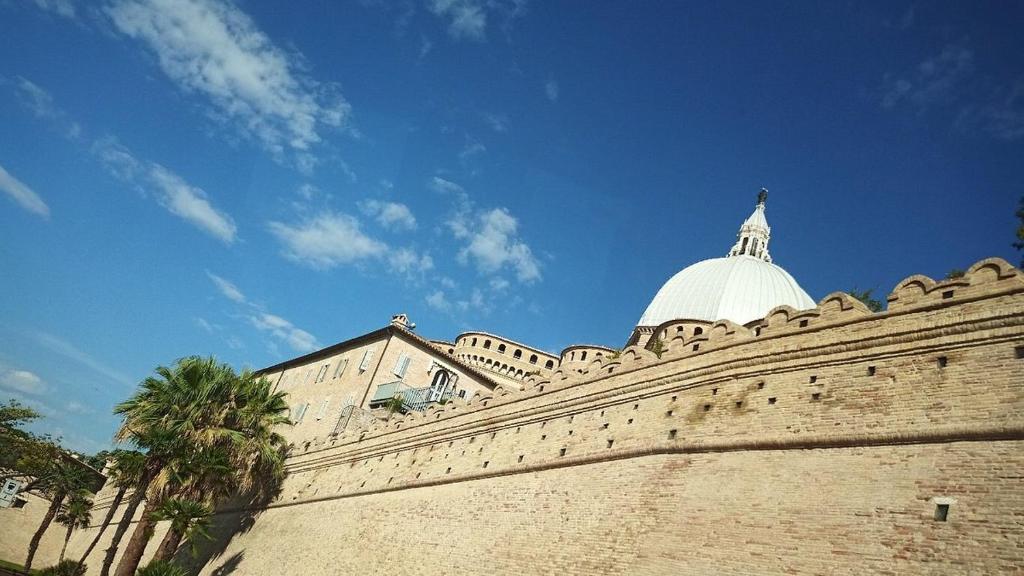 un edificio con una cupola in cima a un muro di Hotel Madonna di Loreto a Loreto