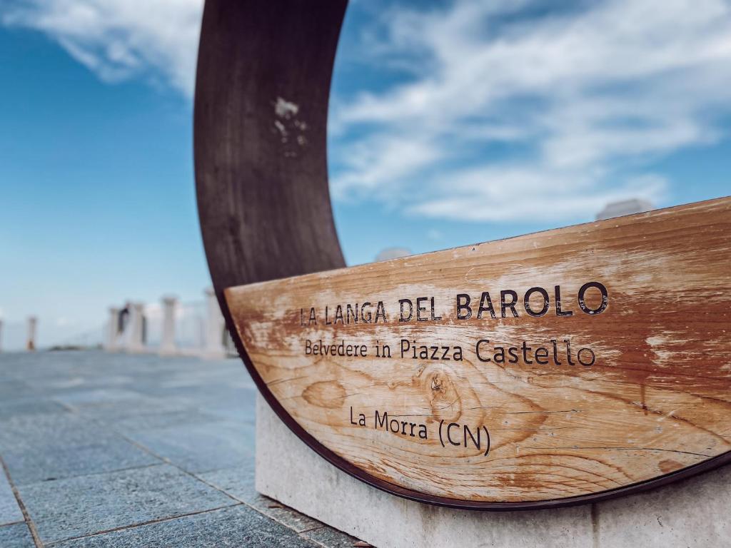 un banco de madera sentado al lado de una calle en La Casa Nelle Aie - Appartamento Dolcetto - Free Wifi & AC, en La Morra