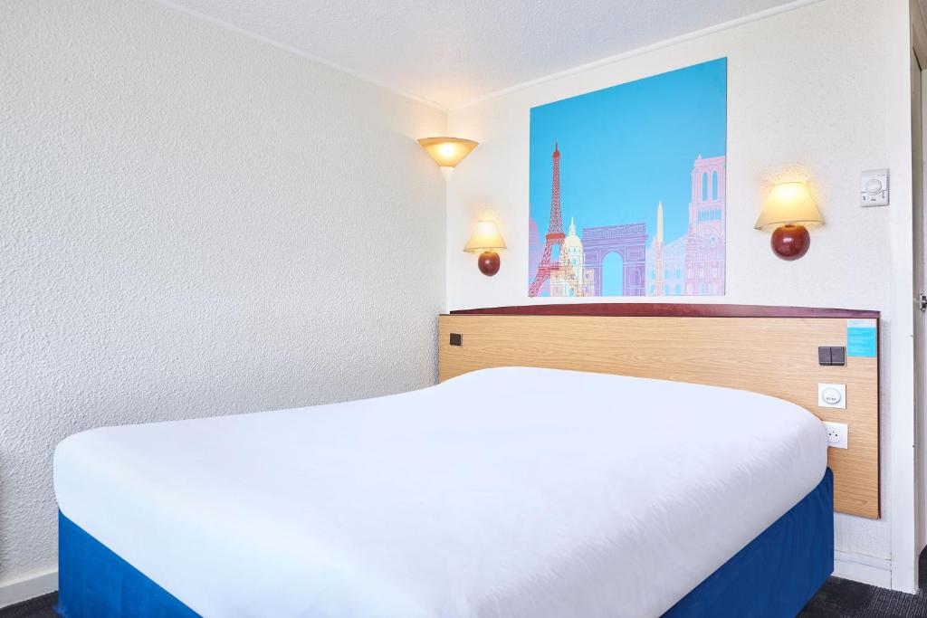 Postel nebo postele na pokoji v ubytování Kyriad Direct Le Bourget Gonesse
