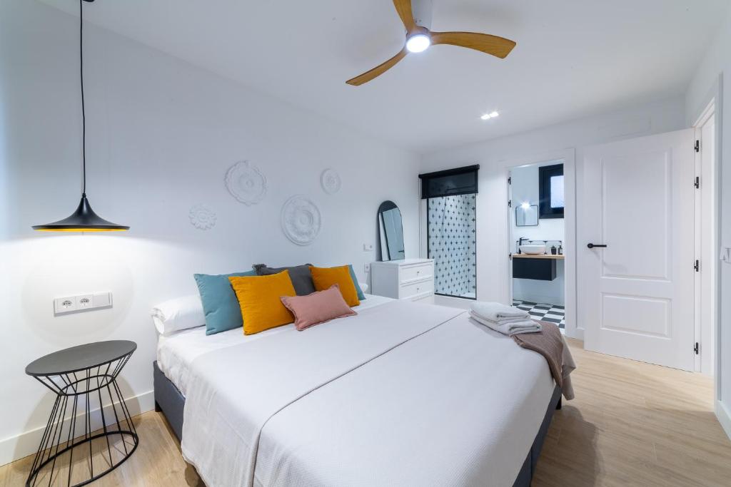 a bedroom with a large white bed with colorful pillows at Exclusivo Loft Catedral in Almería