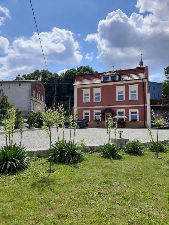 Biała的住宿－Gościniec w Starym Młynie，草上植物的红砖大建筑