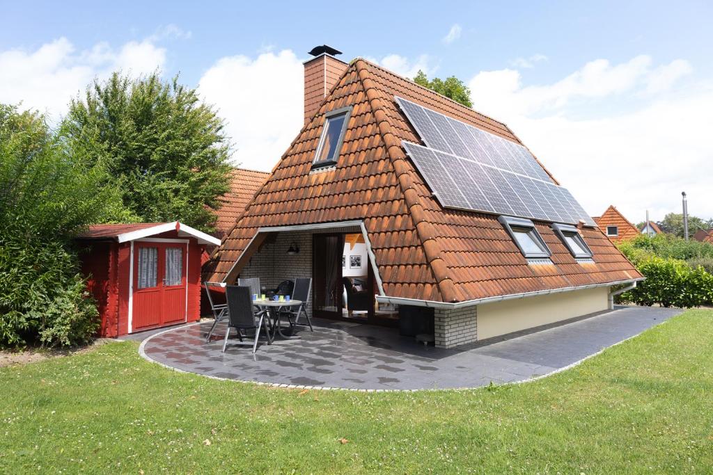 uma casa com um telhado com painéis solares em KS 14 - Strandvogt 2 Komfort em Dorum Neufeld