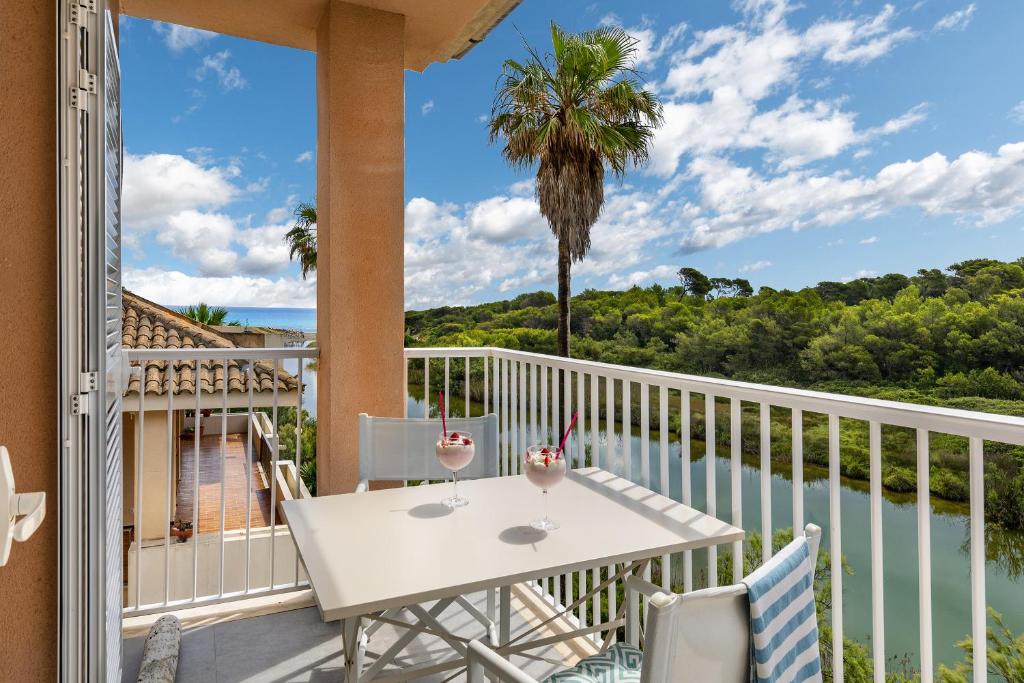 a balcony with a table and chairs and a view of the ocean at Flat just 280 m from the beach in Can Picafort