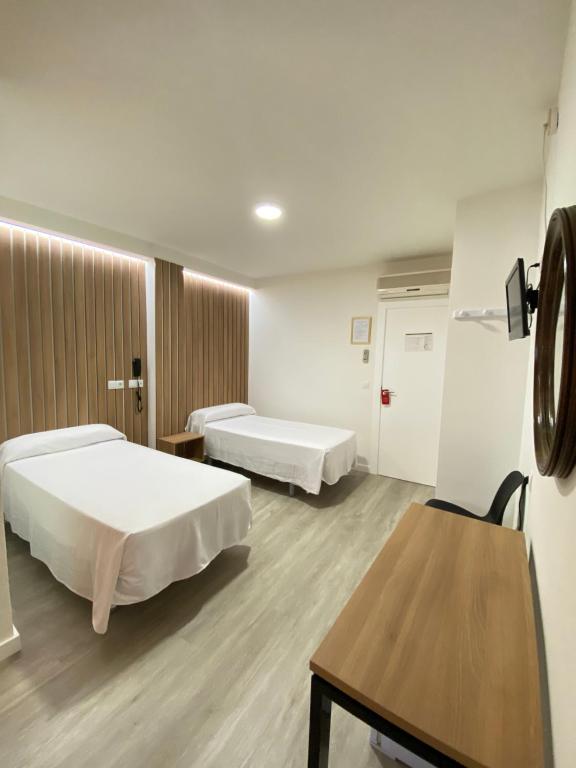 a hospital room with two beds and a table at Hotel Victoria Centro in Almuñécar