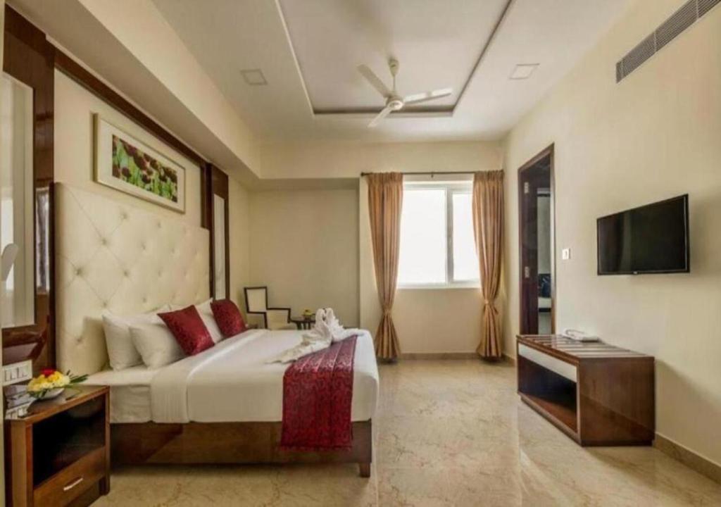 um quarto com uma cama grande e uma televisão em Hotel Star Palace - Rameswaram Tamil Nadu em Rameswaram