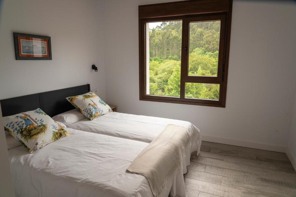Duas camas num quarto com uma janela em La Mina de Vega 