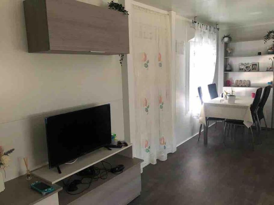 a living room with a television and a dining table at Casita con piscina cerca de Chinchón, Aranjuez y Parque Warner in Colmenar de Oreja
