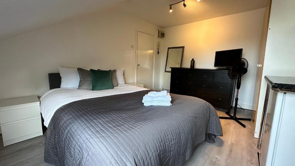 a bedroom with a large bed and a television at Economic Studio in the heart of Chiswick - London in London