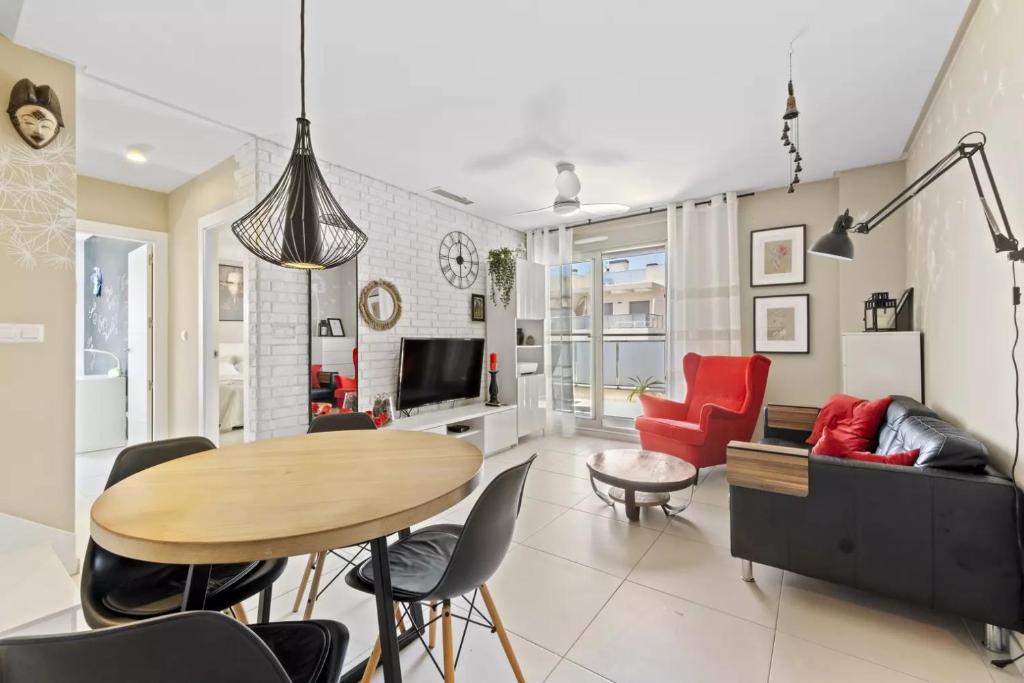a living room with a table and red chairs at 019 Green Hills Apartamento Exclusivo in Campoamor