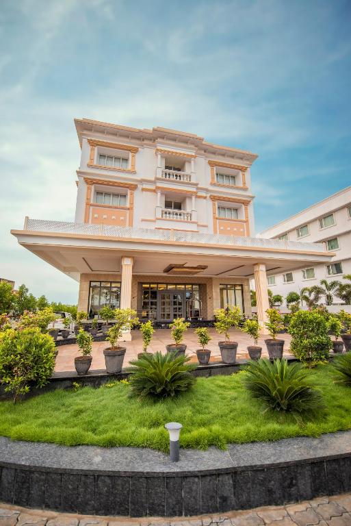 a large building with potted plants in front of it at Hotel Star Palace - Rameswaram Tamil Nadu in Rāmeswaram