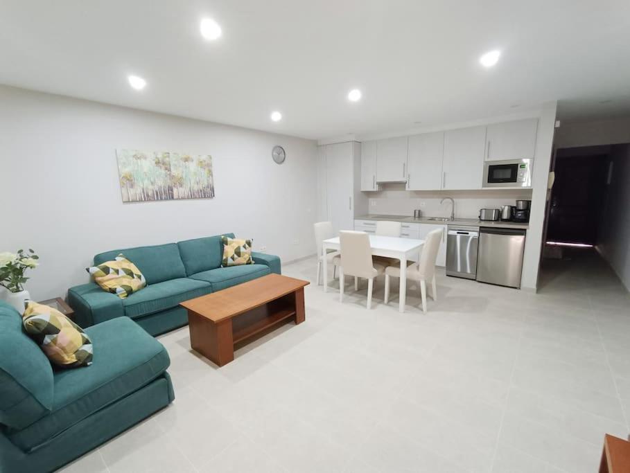 a living room with a blue couch and a table at Apartamento Idaira Sun in Los Cristianos