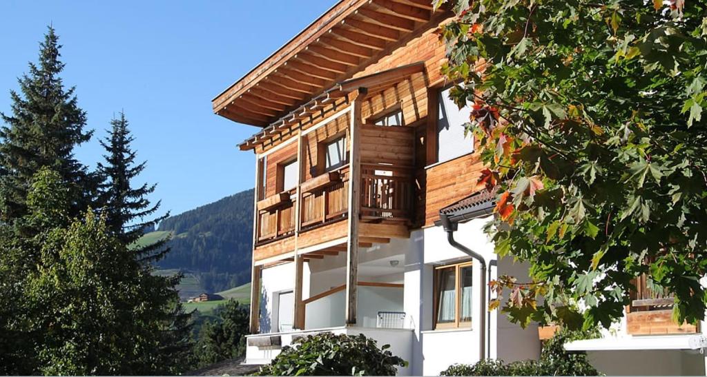 a wooden house with a balcony on a mountain at Apartments Antersi Silvia in San Vigilio Di Marebbe