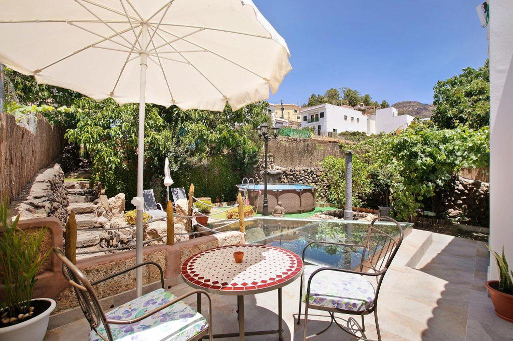 a patio with an umbrella and a table and chairs at Casa Tajinaste in Vilaflor