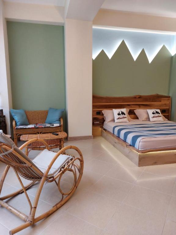um quarto com uma cama e uma cadeira de baloiço em Amara Luxury B&B em Tirana