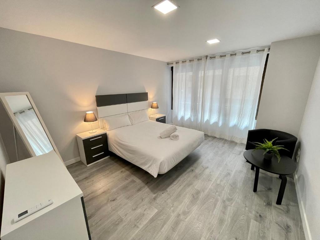 1 dormitorio con cama, escritorio y silla en D.A.U. Centro Parking Opcional, en Salamanca