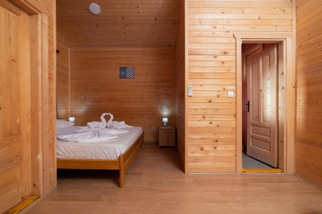 a small bedroom with a bed in a wooden room at Sunny Garden in Ulcinj