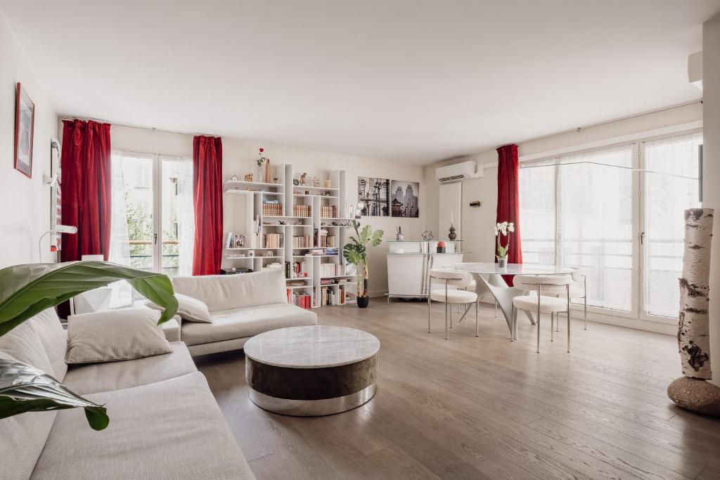 een woonkamer met een bank en een tafel bij Veeve - Belle Blanche in Parijs