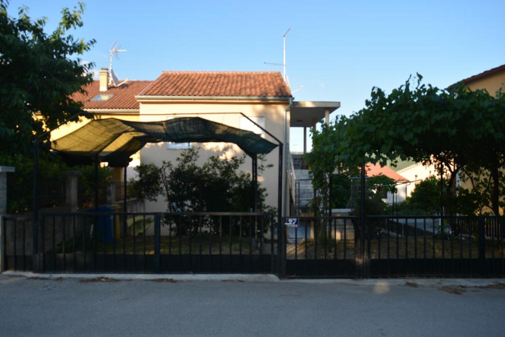a fence in front of a house with a slide at Apartment Dragica in Kornić