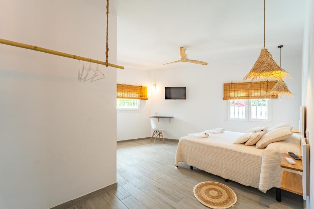 a white bedroom with a bed and a table at Calas De Meca in Los Caños de Meca