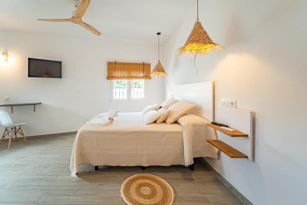 a bedroom with a bed and a desk and a tv at Calas De Meca in Los Caños de Meca
