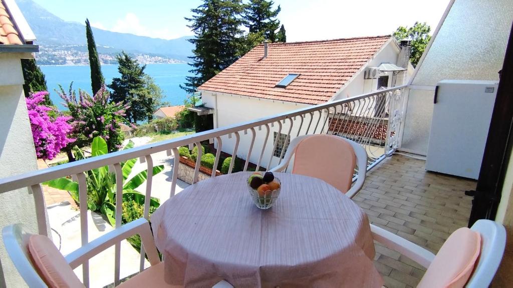una mesa con un bol de fruta en el balcón en Guesthouse Gavrilović 28 A en Njivice