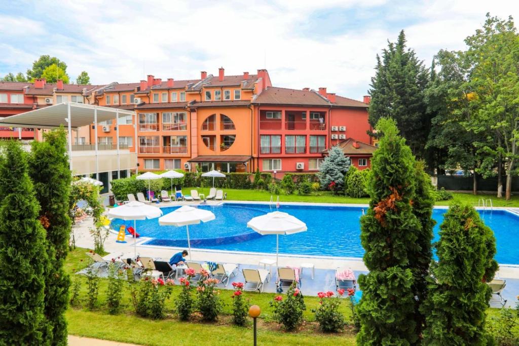 a hotel with a swimming pool in front of a building at Oasis dream apartment with pool by the sea in Nesebar