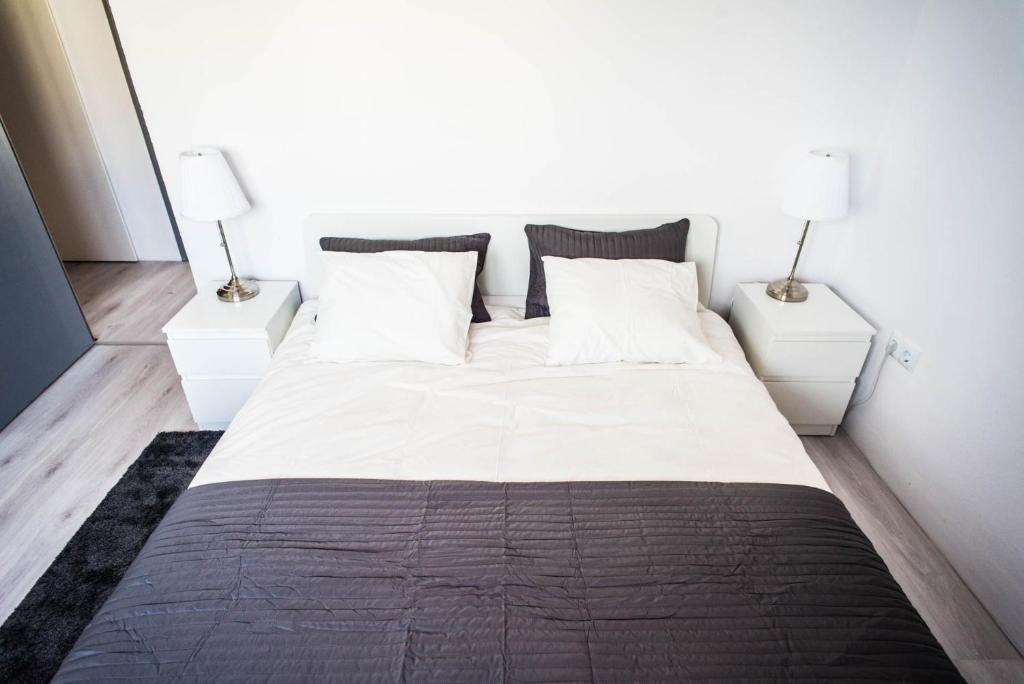 een slaapkamer met een groot wit bed en 2 nachtkastjes bij Beach Lovers' Paradise, bright apartment for 2/3 in Vilanova i la Geltrú