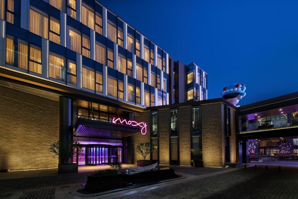 a building with a neon sign in front of it at Moxy Xi'an Downtown in Xi'an