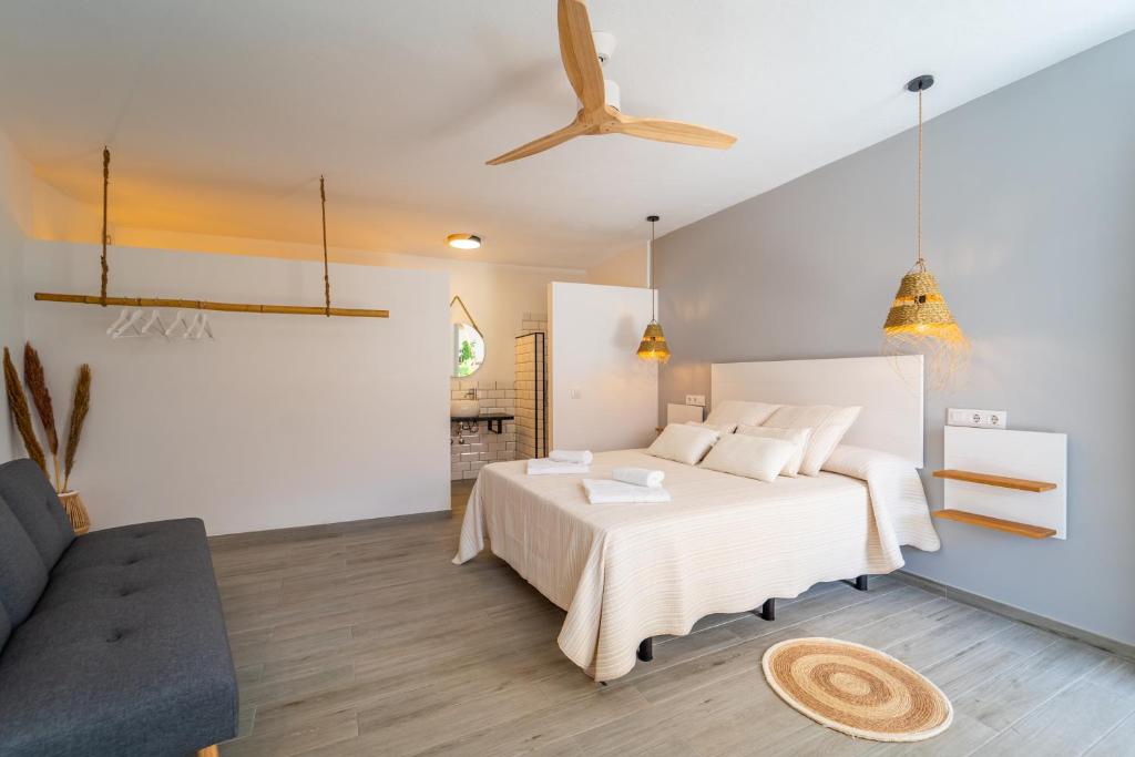 a bedroom with a white bed and a couch at Calas De Meca in Los Caños de Meca