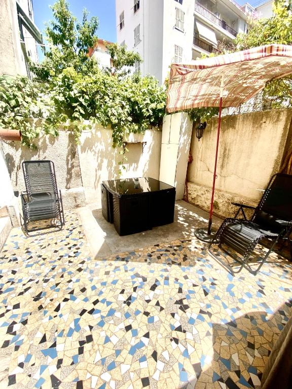 un patio avec une baignoire et des chaises sur un sol carrelé dans l'établissement Grand T2 en rez de chaussée avec grande terrasse proche du centre ville tramway à 2 mn, à Nice