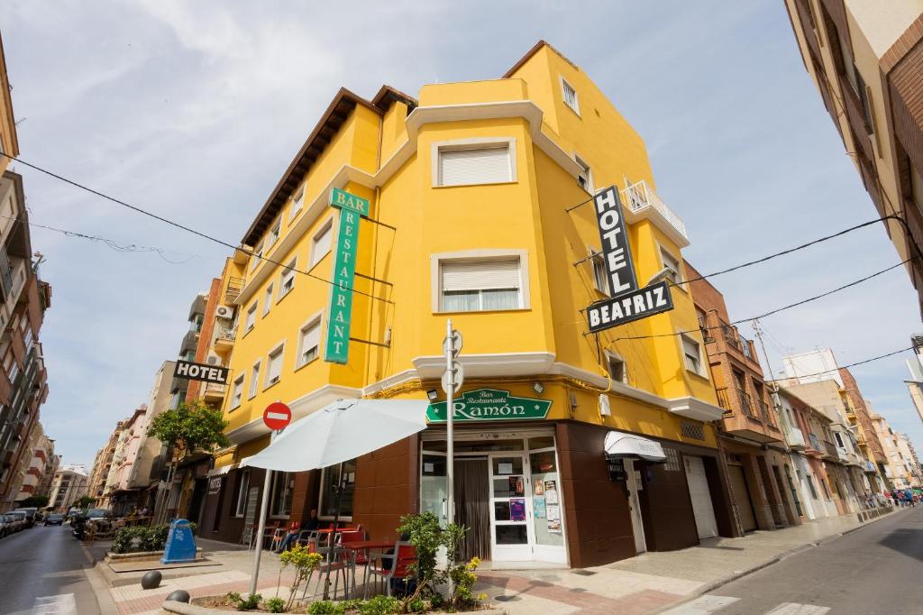 un edificio giallo all'angolo di una strada di Hotel Beatriz a Burriana