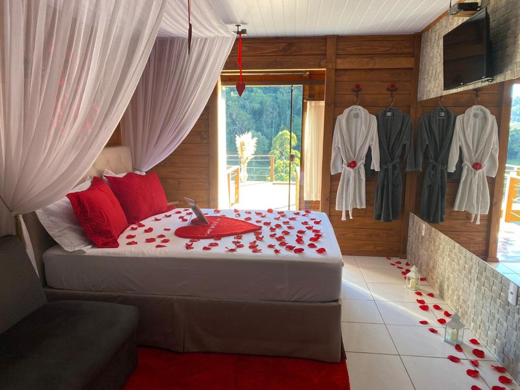 a bedroom with a bed with red roses on it at Cabana Amor Perfeito in Alfredo Wagner