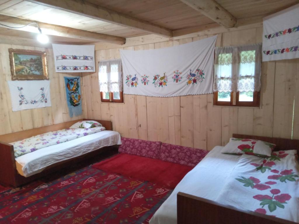 Pokój z 2 łóżkami i czerwonym dywanem w obiekcie Isov Ranch w mieście Plav