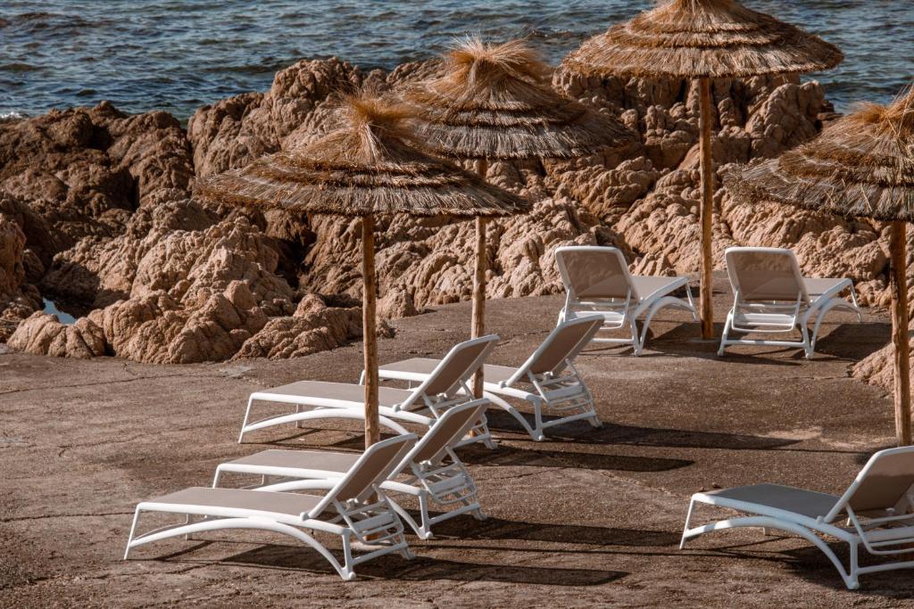 un gruppo di sedie e ombrelloni in spiaggia di Hôtel Restaurant Dolce Vita ad Ajaccio