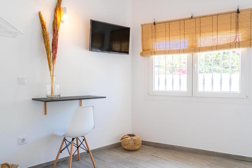 a room with a chair and a tv and a window at Calas De Meca in Los Caños de Meca