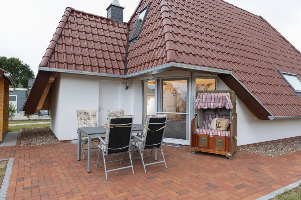uma casa com uma mesa e cadeiras num pátio em MP 18 - Strandvogt 3 Komfort em Dorum Neufeld