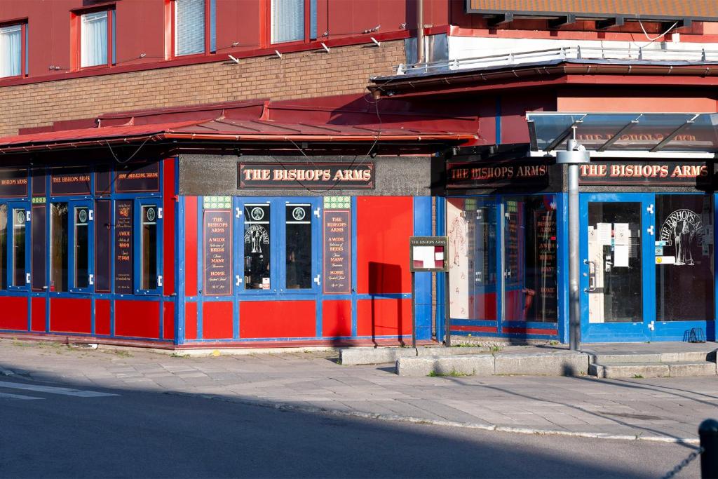 ein rotes und blaues Gebäude auf der Straßenseite in der Unterkunft Hotel Bishops Arms Kiruna in Kiruna