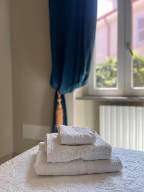 Dos toallas están apiladas en una cama frente a una ventana. en B&B Licia Home, en Voghera