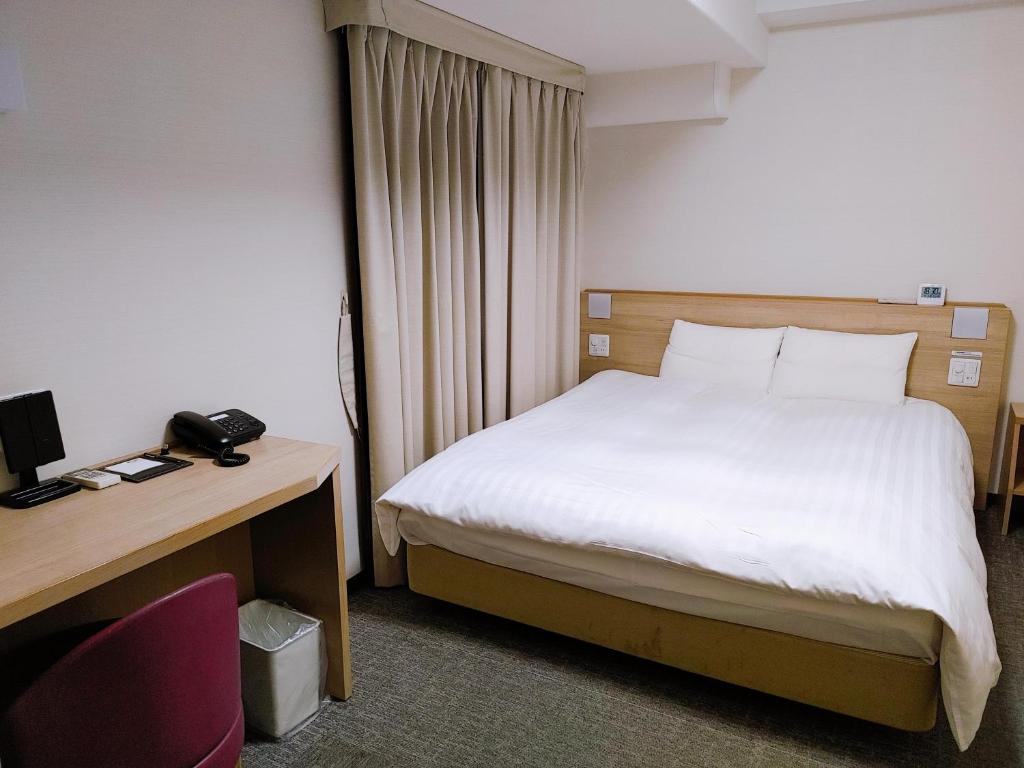 Postel nebo postele na pokoji v ubytování Dormy Inn Express Matsue